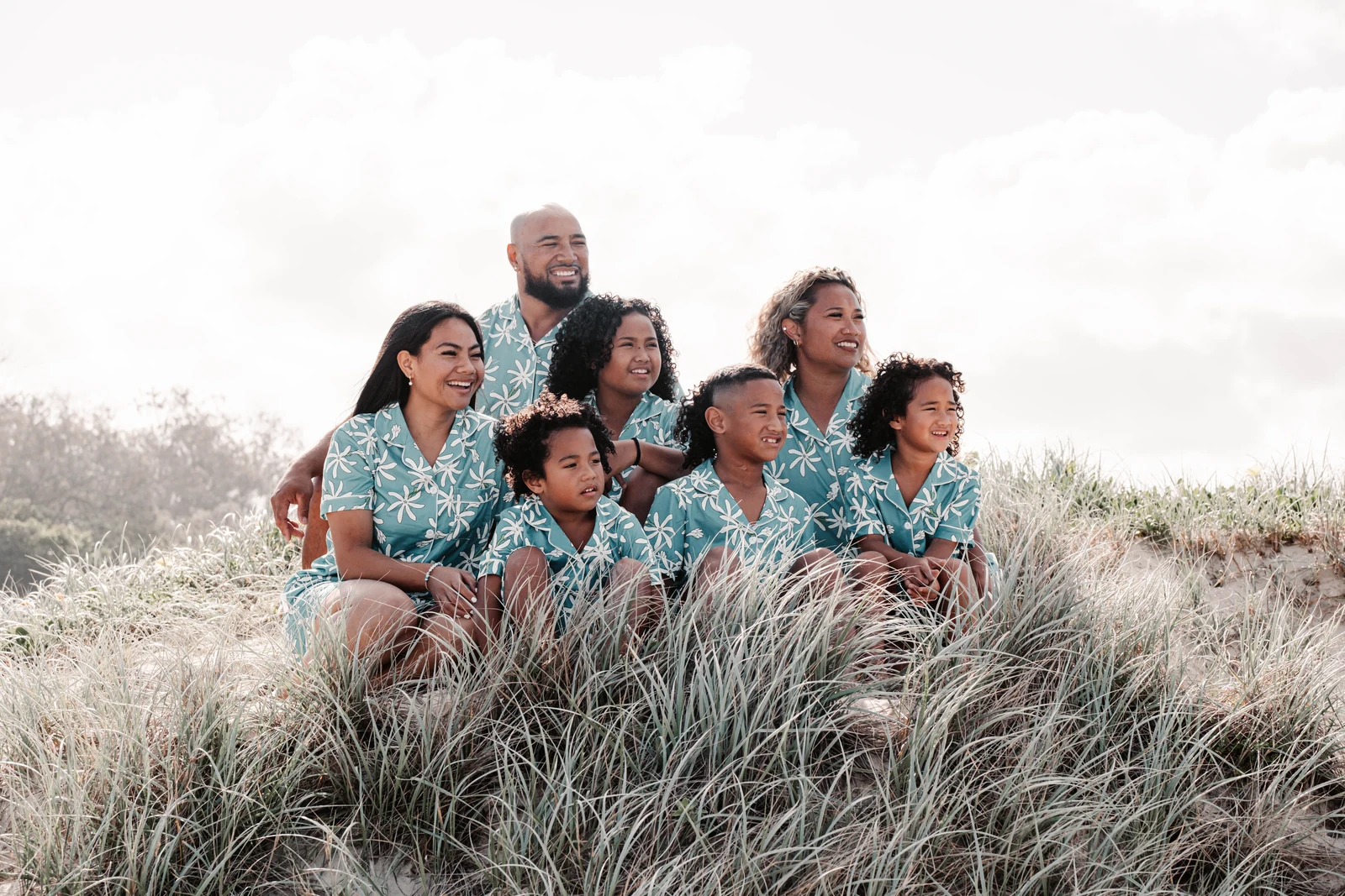 A family sitting on a sand dune